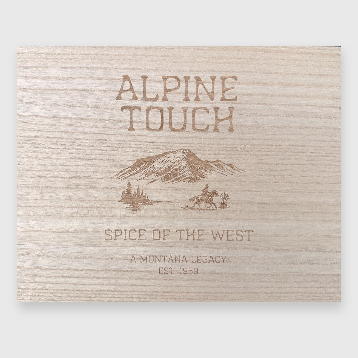 Alpine Touch Montana's Special Spice Cache wooden gift box lid engraved with mountains, cowboy on horseback, and 'Spice of the West – A Montana Legacy, Est. 1959'
